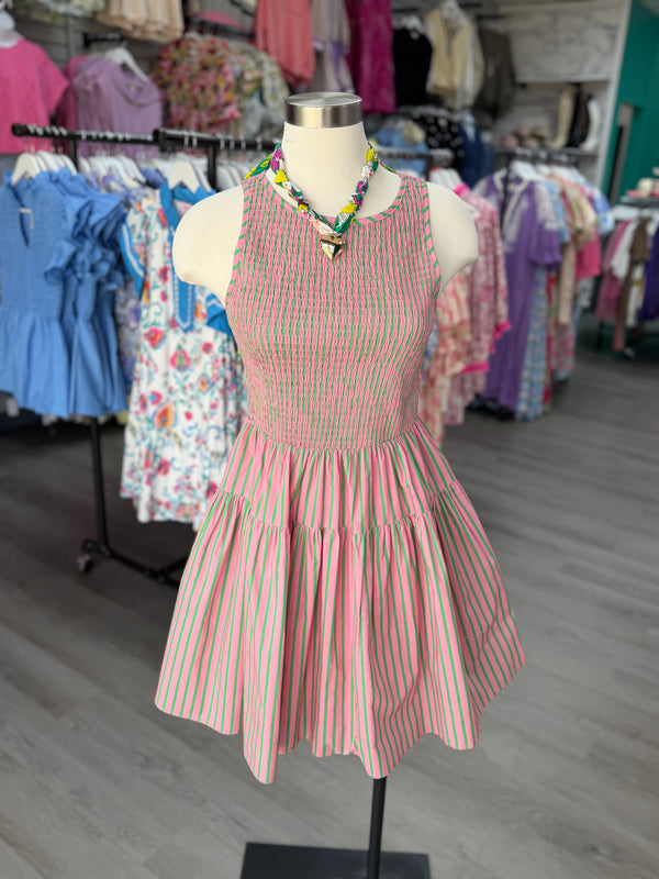Mannequin wearing a pink and green striped dress in a clothing store.