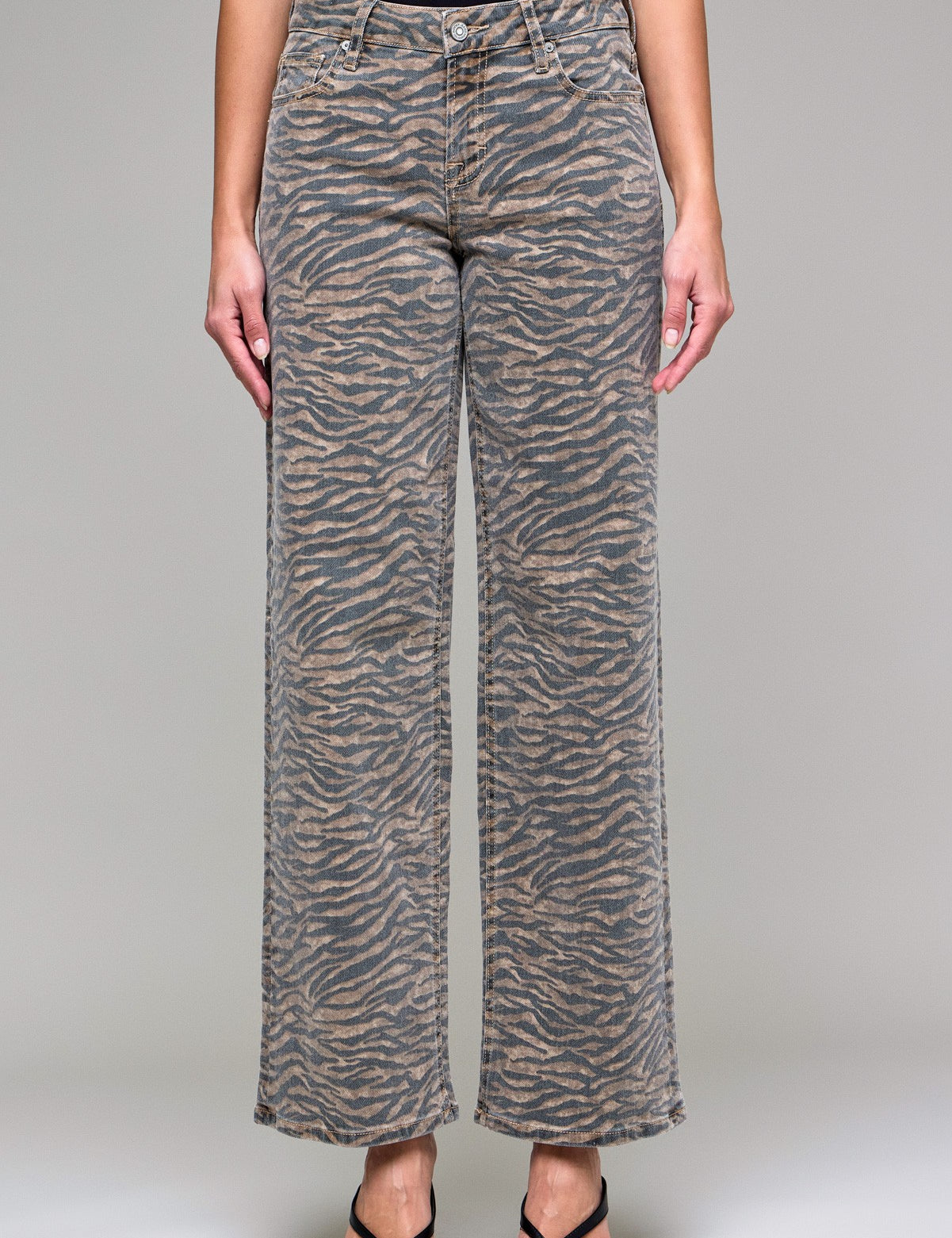 Person wearing zebra print pants on a plain background