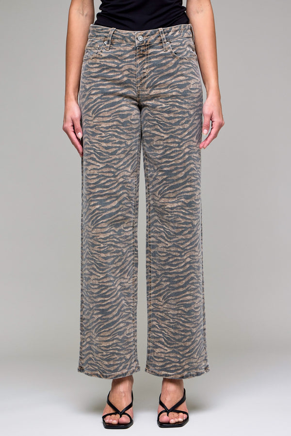 Person wearing zebra print pants on a plain background