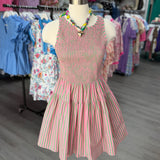 Mannequin wearing a pink and green striped dress in a clothing store.