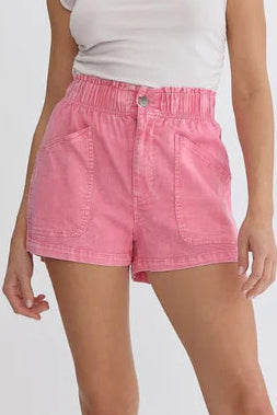 Woman wearing pink shorts and beige knee-high boots on a white background