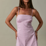 Woman wearing a pink dress against a neutral background